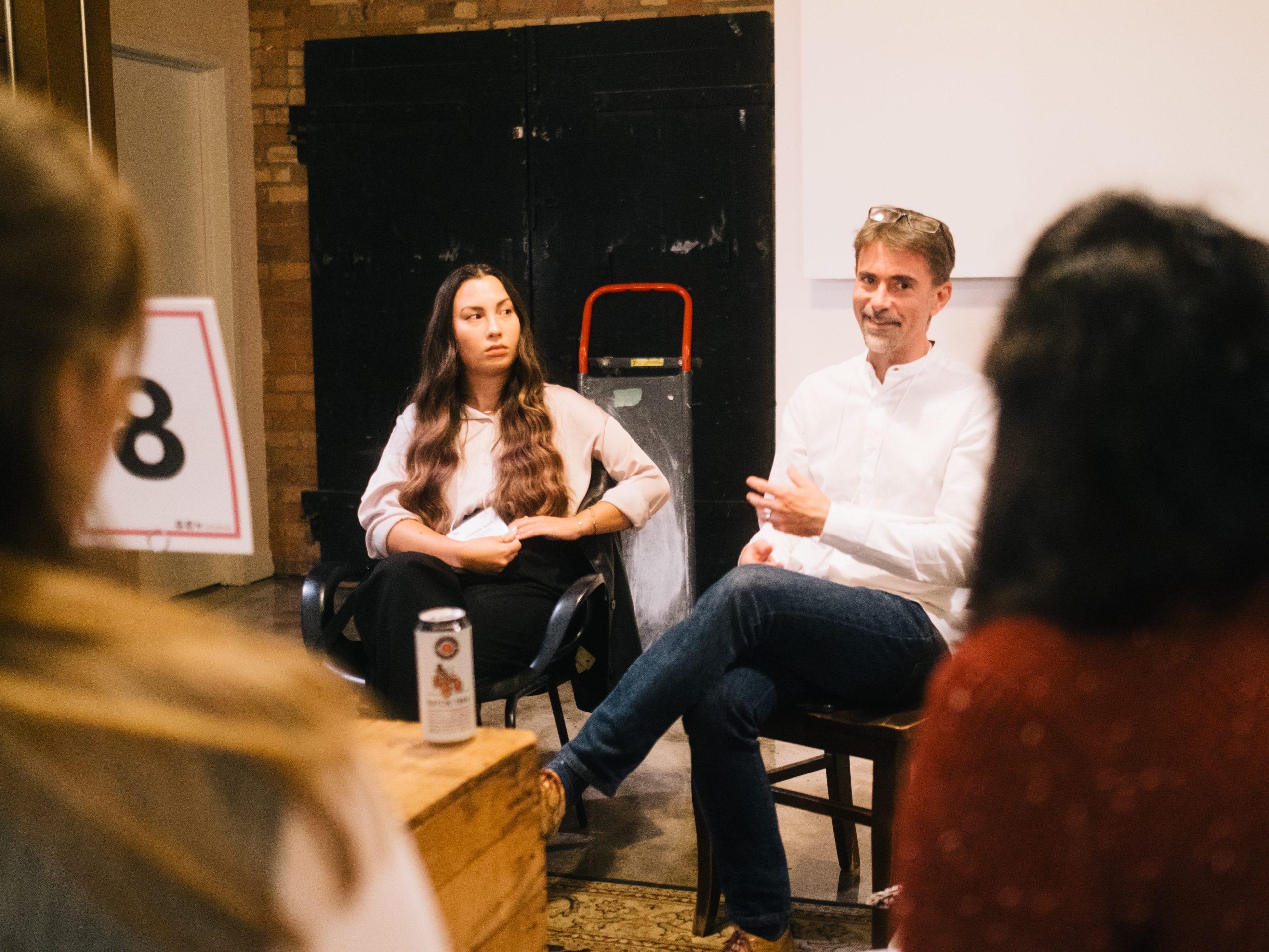 Featured Guests in conversation with attendees sitting around a talking circle, titled 'Table 8.'
